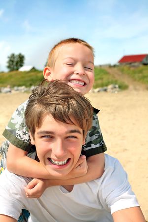 happy teenager and kid on the beachの写真素材