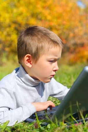 concentrated boy with notebook on the meadowの写真素材