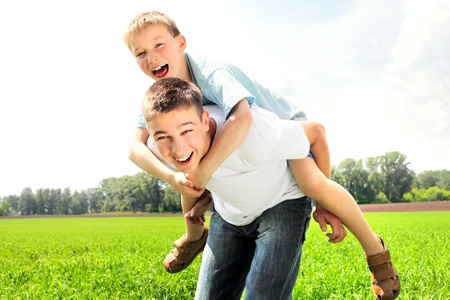 happy brothers playing in the summer fieldの写真素材