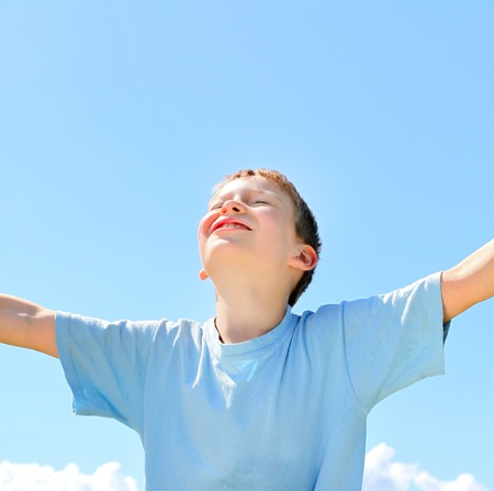 happy boy on the blue sky backgroundの写真素材