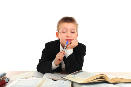 bored and tired schoolboy on the tableの写真素材