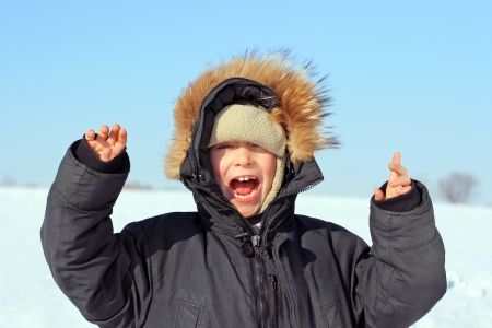 Happy Boy with Hands up in the Winter fieldの写真素材