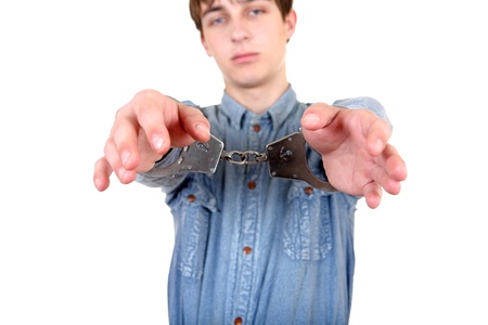 Young Man in Handcuffs on the White Background  Focus on Handcuffs