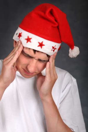 Young Man in Santa's Hat got headache after Partyの写真素材