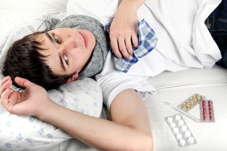 Diseased Young Man lying on the Bedの写真素材