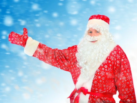 Santa Claus shows the way with a hand on the Abstract Winter Backgroundの写真素材
