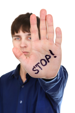 Teenager shows the palm gesture with an inscription â Stop. Isolated on the Whiteの写真素材