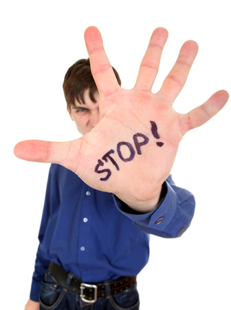 Teenager shows the palm gesture with an inscription â Stop. Isolated on the Whiteの写真素材