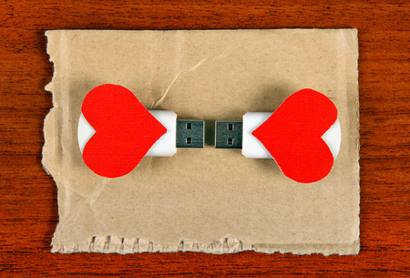 Two USB Flash Drive with Heart Shapes on the Wooden Backgroundの写真素材