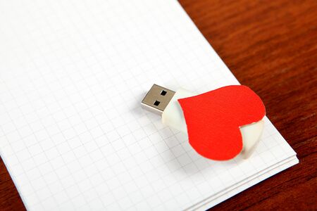 USB Flash Drives with Heart Shape on the Blank Note Padの写真素材