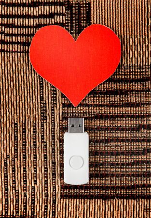 USB Flash Drive with Heart Shape on the Fabric Backgroundの写真素材
