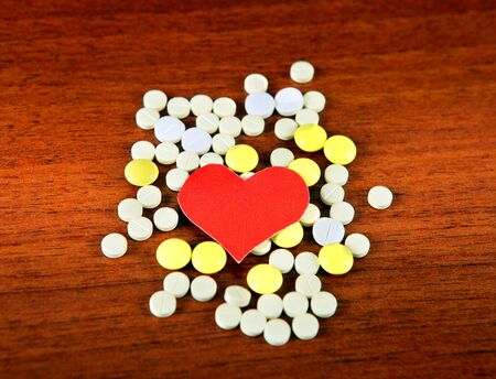 Heart Shape with the Pills on the Wooden Backgroundの写真素材