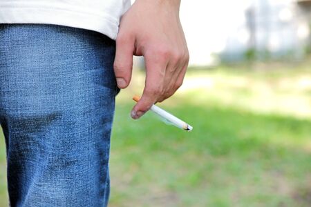 Man hold a Cigarette in the Hand closeup outdoorの写真素材