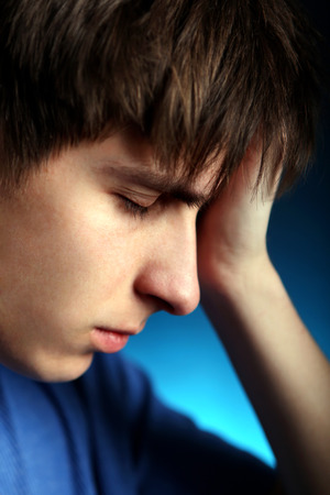 Sad Young Man in the Dark Room closeupの写真素材