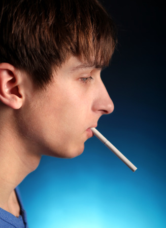 Young Man with Cigarette in the Dark Roomの写真素材