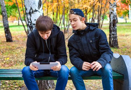 Boys with Tablet Computer in the Autumn Parkの写真素材