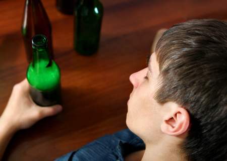 Tired Young Man with Bottle of the Beer at the Homeの写真素材