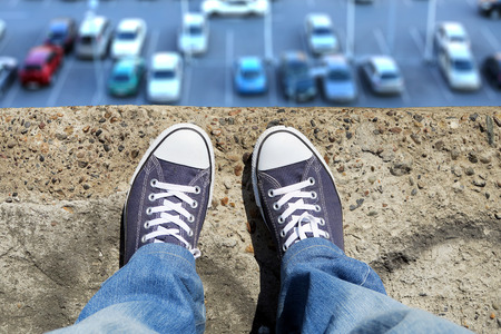 Person in the Jeans and Sneakers on the Edgeの写真素材