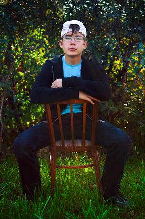 Teenager sit on the Chair on the Nature Background