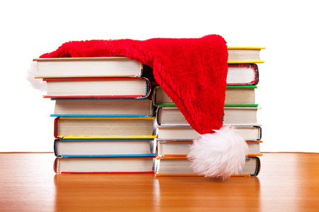 Santa Hat on the Books at the Table on the White Backgroundの写真素材