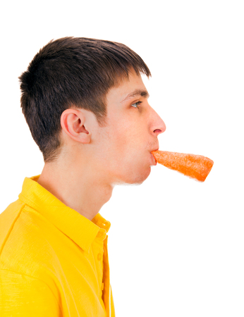 Young Man with a Carrot in his Mouth Isolated on the White Backgroundの写真素材