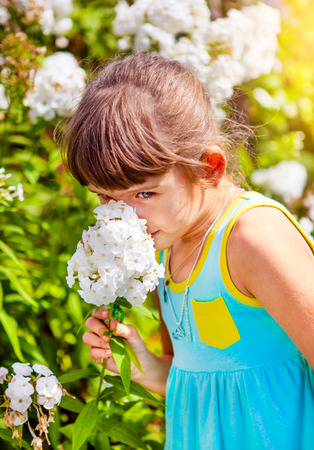 Small Girl with a Flower in the Summer Gardenの写真素材