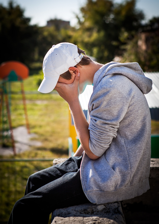 Sad Teenager sit on the Roof Of the Buildingの写真素材