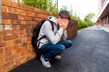 Sad Young Man sit on the City Streetの写真素材