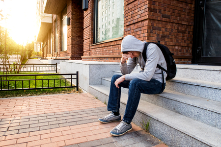 Sad Young Man sit on the City Streetの写真素材