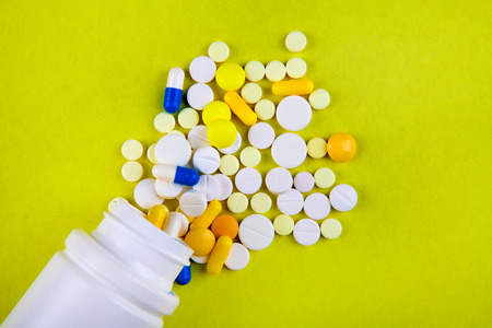 Pills and Vial on the Yellow Background closeupの写真素材