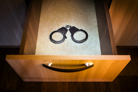 Handcuffs in the Opened Drawer of the Furnitureの写真素材