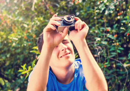 Toned Photo of Young Man with a Vintage Photo Camera outdoor