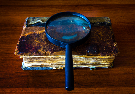 Old Book with a Magnifying Glass on the Table closeupの写真素材