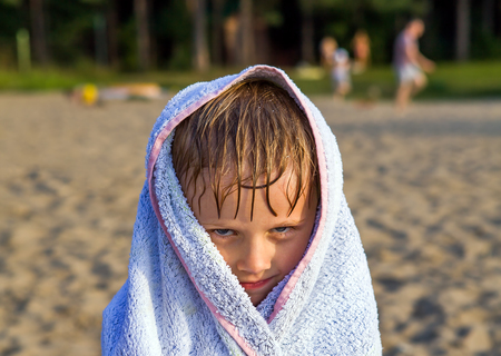 Little Kid in the Bath Towel on the Summer Beachの写真素材