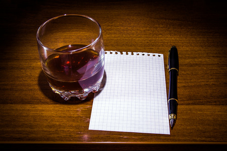 Glass of the Whiskey and Empty Paper on the Table closeupの写真素材