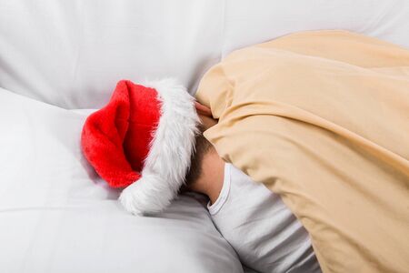 Rear View of a Man in Santa Hat sleep in the Bedの写真素材