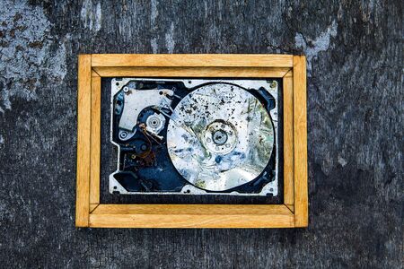 Crushed Hard Disk Drive in the Frame on the Old Wooden Background closeup