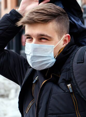 Young Man in the Flu Mask on the City Street Portrait closeupの写真素材