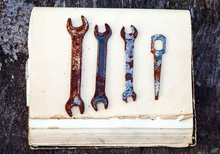 Old Rusty Tools on the Old Book and Wooden Background closeup