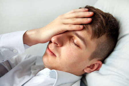 Sad Young Man in the Bed at the Home closeupの写真素材