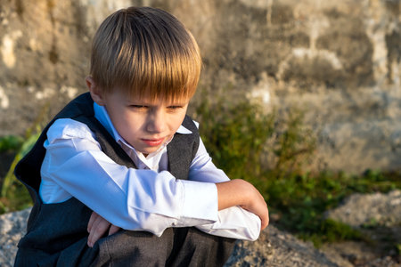 Portrait of a Sad Kid on the Concrete Wall outdoorの写真素材