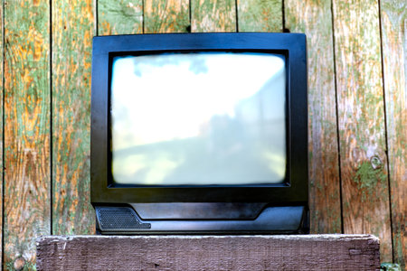 Old Analog Television Set on the Weathered Wooden Planks Backgroundの写真素材