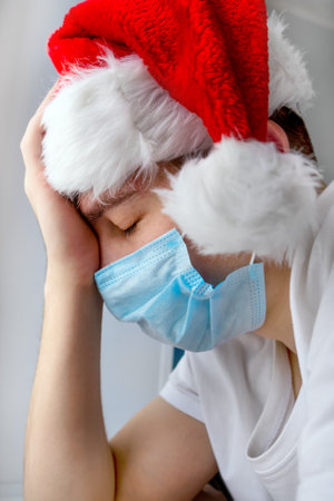 Sad Young Man in Santa Hat by the Wall closeupの写真素材