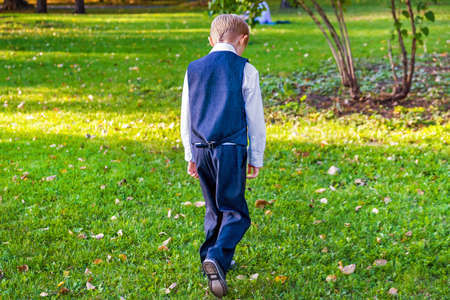 Rear View of a Sad Kid wakling in the Parkの写真素材