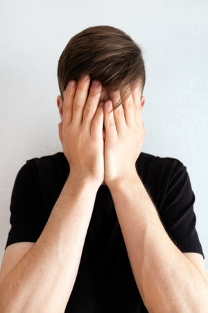 Sad Young Man by the White Wall closeup