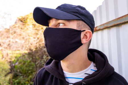 Young Man in the Flu Mask on the Old Wall Background outdoor