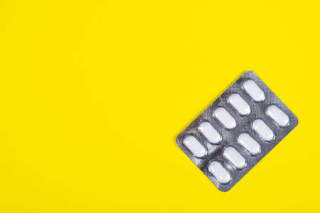 Pills Pack on the Yellow Paper Background closeup