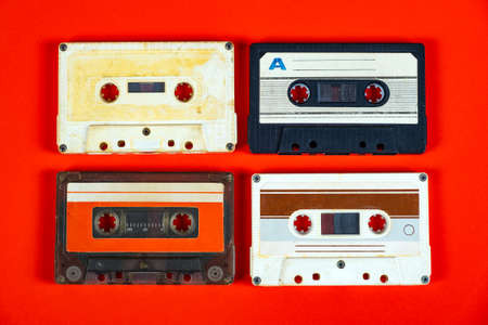 Four Old Audio Cassettes on the Red Paper Background closeupの写真素材