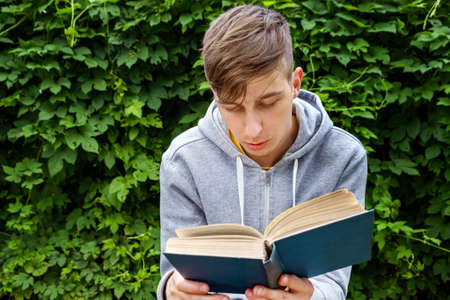 Young Man with a Books in the Summer Park