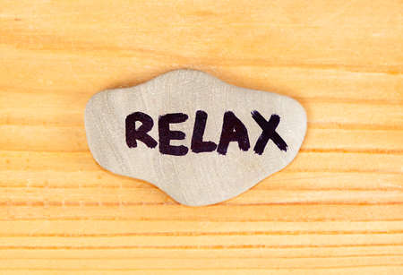 Inscription Relax on the Pebble on a Wooden Planks Background closeupの写真素材